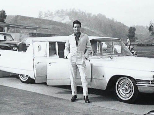 Elvis posing next to limo
